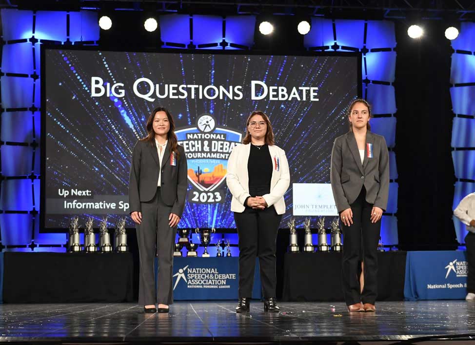Group of students on the National Tournament stage with their trophies.