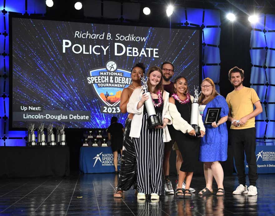 Group of students on the stage with their trophies at the National Tournament
