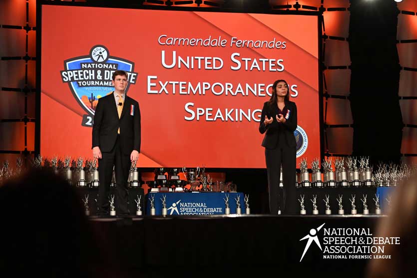 Group of students on the National Tournament stage with their trophies.